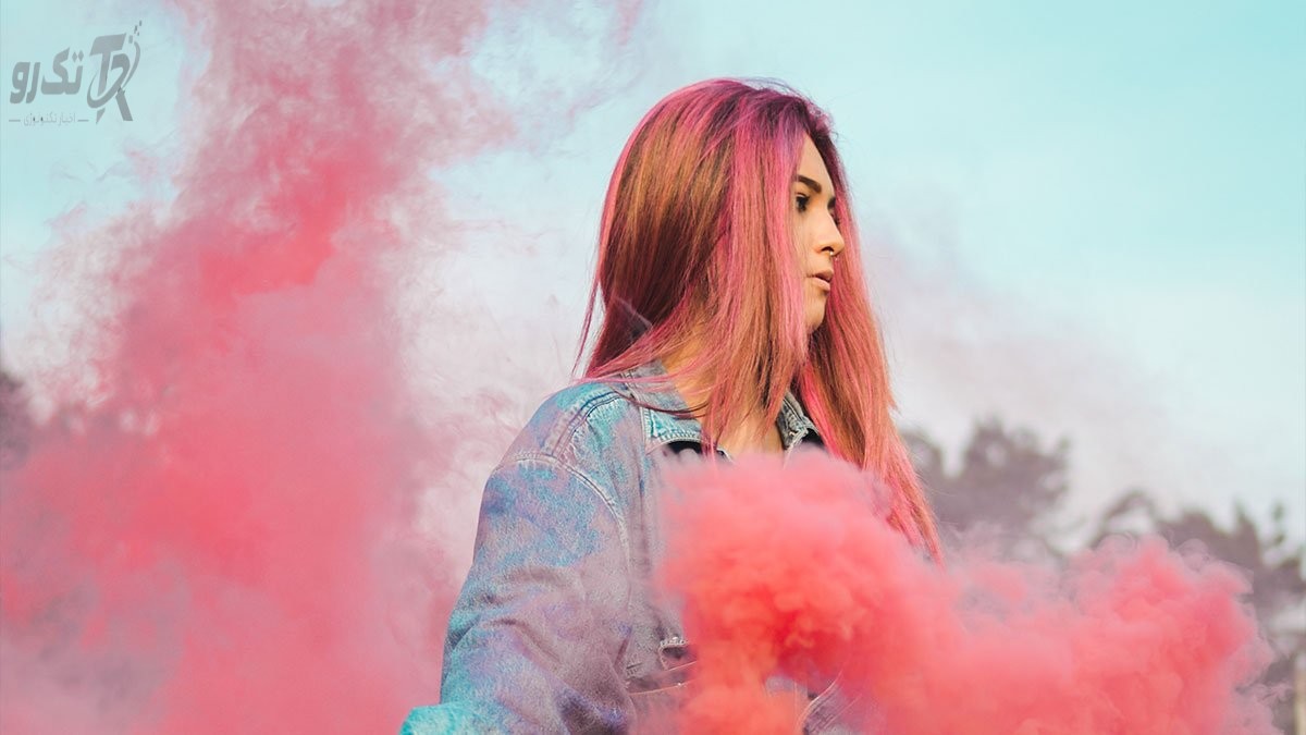Woman wearing a blue on leather by pink smoke